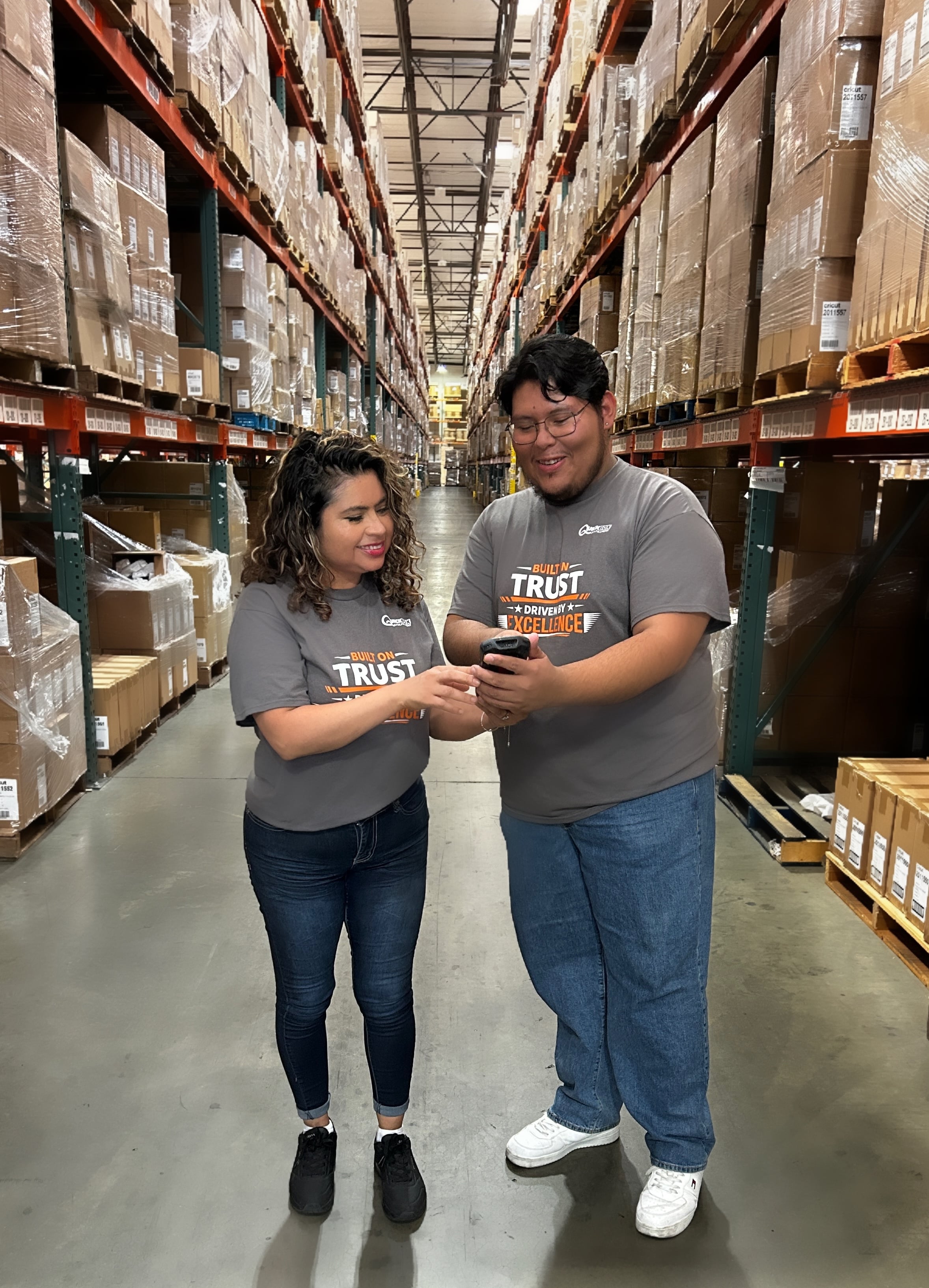two warehouse workers at QuickBox working in a warehouse aisle
